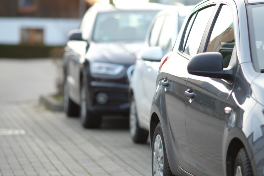 Closeup shot black car parking lot with blurred background 1 scaled