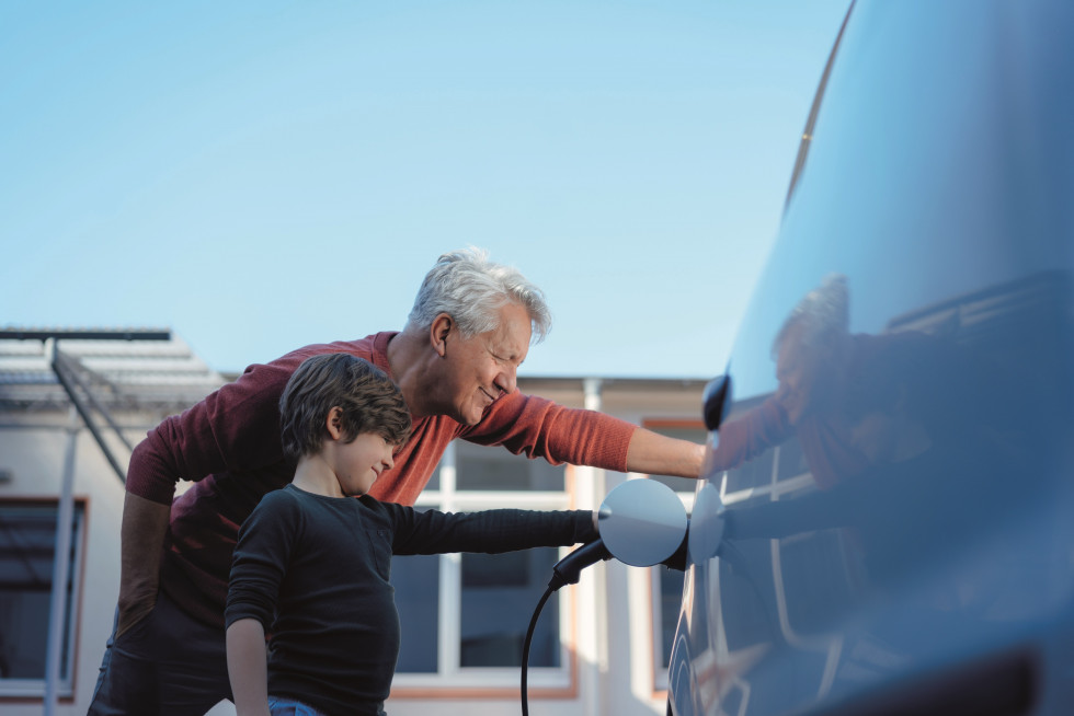 SonnenBatterie 10 performance Grandpa and grandson charging EV PRINT